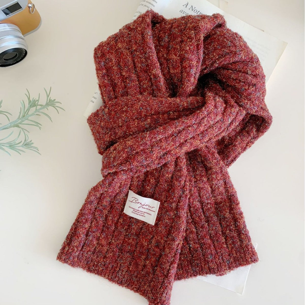 Chunky red knit scarf with textured winter weave, laid out on a flat surface.