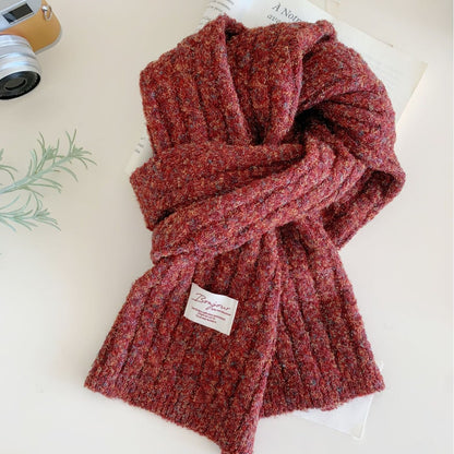 Chunky red knit scarf with textured winter weave, laid out on a flat surface.