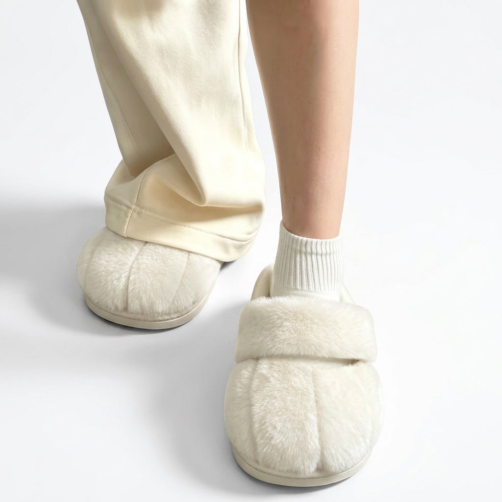 Cream fluffy slippers with toe indentations worn with white socks and cream pants.