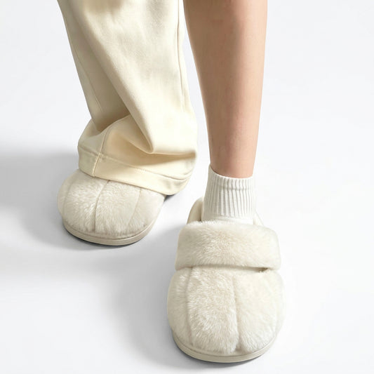 Cream fluffy slippers with toe indentations worn with white socks and cream pants.