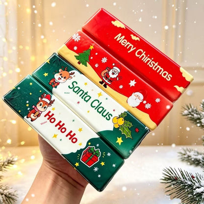 Hand holding four Christmas butter-stick squishy toys with Santa and reindeer designs