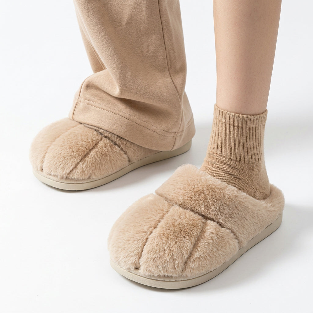 Beige fuzzy slippers shaped like cat paws worn with matching socks and pants.