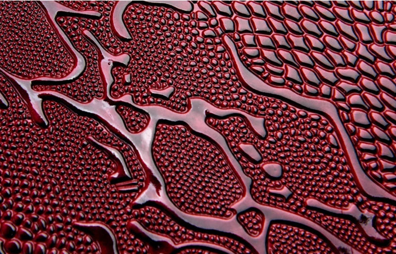 Dark red polished leather with embossed scale texture for a large capacity structured shoulder tote.