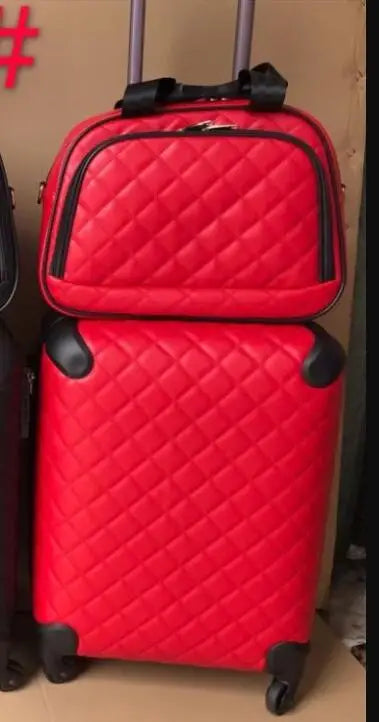 Red quilted leather luggage set with a trolley suitcase, matching vanity case, and black corner guards.