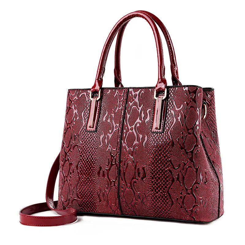 Red snake-patterned structured shoulder tote with zip closure for daily essentials.