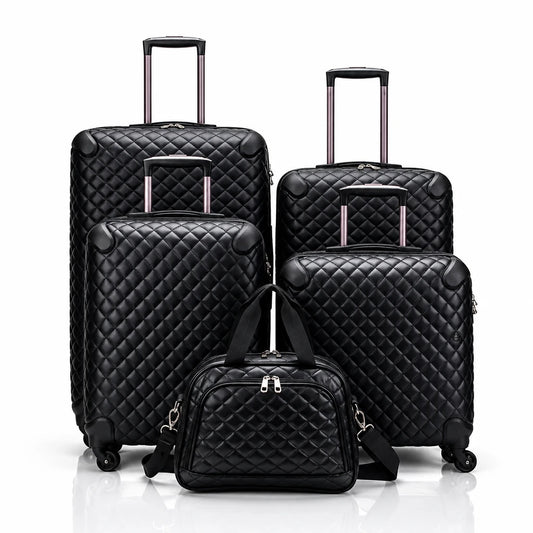 Four black quilted spinner suitcases of varying sizes with retractable handles and a matching quilted travel bag in front.