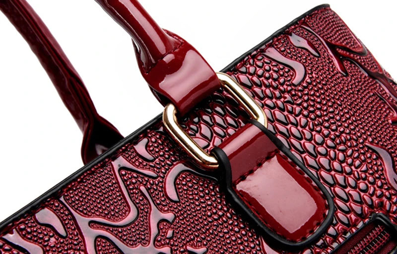 Deep red, faux leather shoulder tote with snake-embossed pattern, gold metal hardware, and zip closure for daily use.
