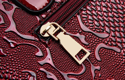 Deep red embossed faux leather bag with a gold-tone zip closure for everyday use.