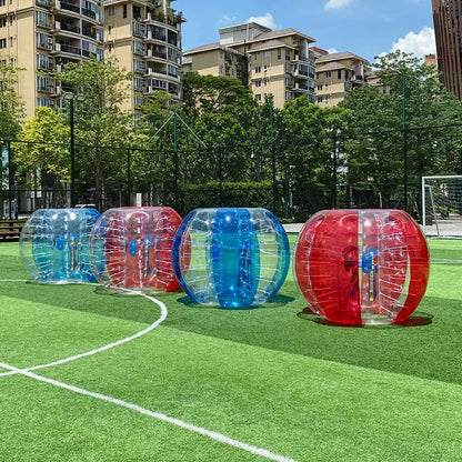Translucent red and blue TPU bumper balls for outdoor sports games on a green field.