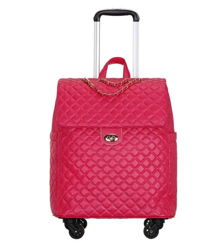 Hot pink quilted PU leather rolling luggage with gold turn-lock closure, chain detail, extendable handle, and wheels.