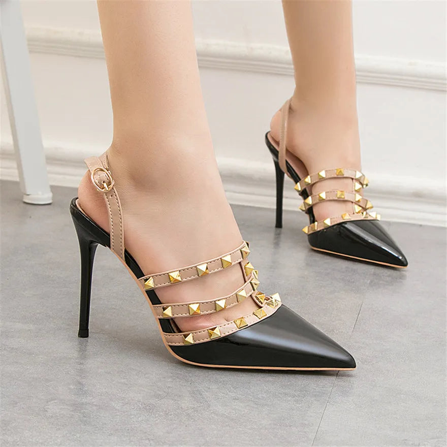 Black patent pumps with studded beige straps and adjustable ankle closure, a non-slip office dress shoe.