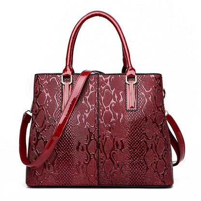 Dark red faux leather crossbody bag with snake skin texture, structured frame, and adjustable strap for daily carry.