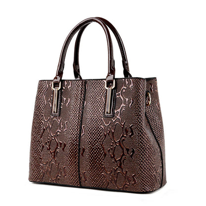 Brown, textured faux leather structured tote bag with shiny top handles for daily carry.