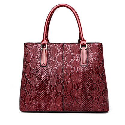 Red faux leather structured shoulder bag with a snake skin pattern for daily carry.