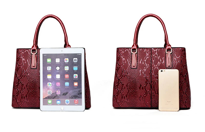 Burgundy snake-pattern faux leather structured shoulder tote with large capacity for carrying devices.