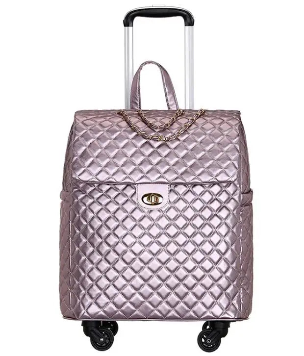 Metallic pink quilted PU leather rolling cabin luggage with a top handle, chain accent, and turn-lock closure.