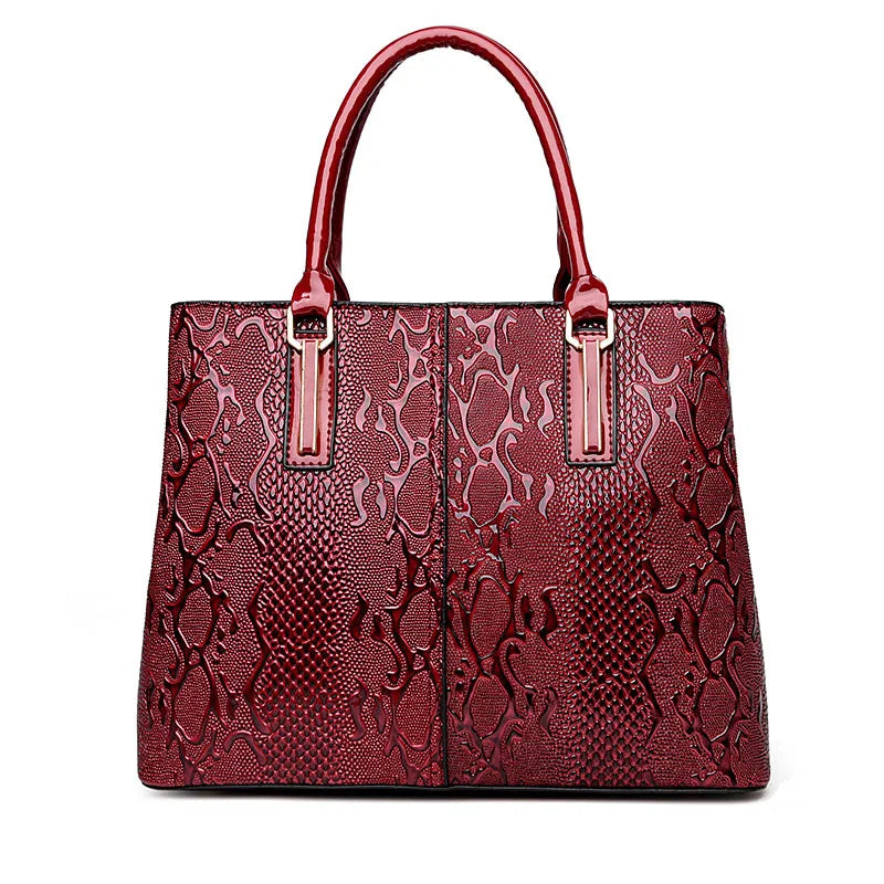 Red faux leather shoulder tote with snake print texture, gold hardware, and zip closure for everyday office use.