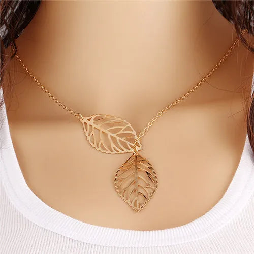 Gold-colored metal chain necklace featuring two openwork leaf pendants.