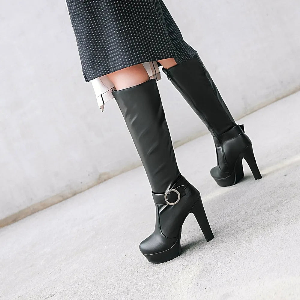 Black knee-high leather boots with platform heels and a buckled strap detail around the ankle.