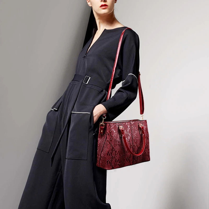 Red snakeskin structured crossbody bag with adjustable strap for everyday carrying.