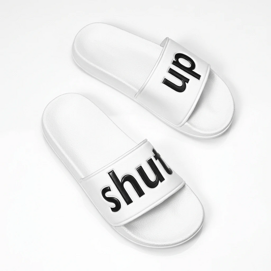 White slide sandals with black raised lettering spelling shut up across the straps.