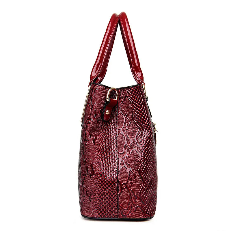 Glossy red faux leather shoulder tote with a structured snake print design for daily essentials.