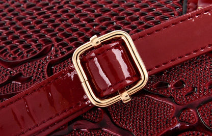 Dark red faux leather shoulder tote with gold buckle and adjustable strap for daily carry.