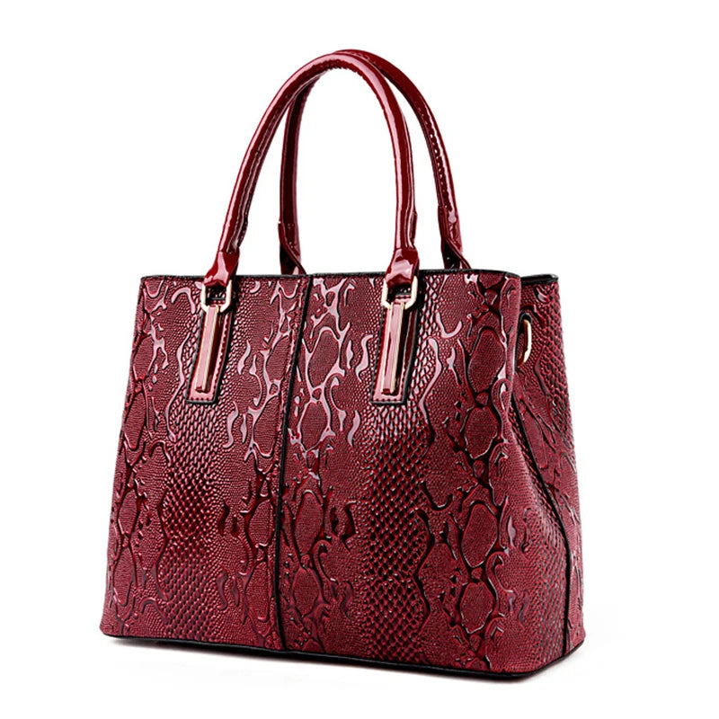 Red snakeskin-patterned structured shoulder tote with dual handles for daily organization.