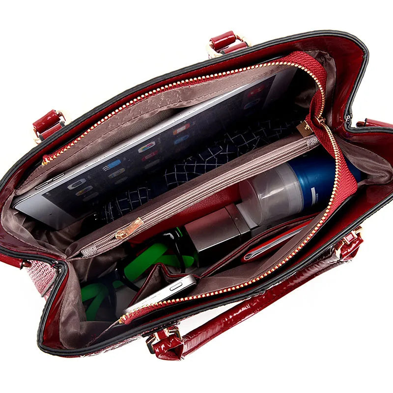 Red faux leather structured shoulder tote with a zip closure and multi-pocket interior to organize daily essentials.
