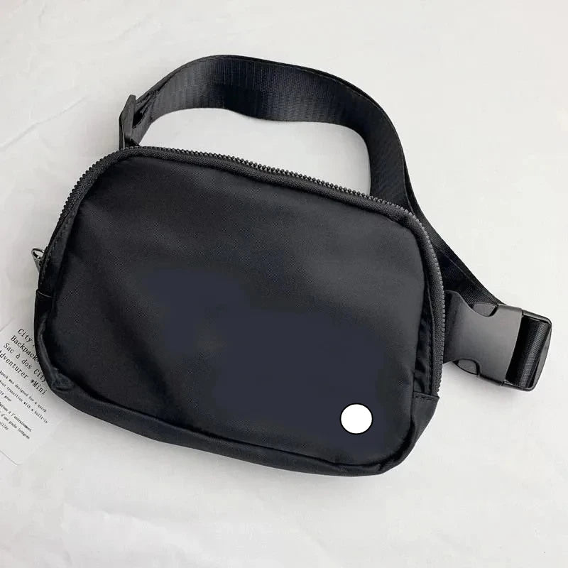 Black waterproof crossbody with zip closure and adjustable strap for running and yoga.