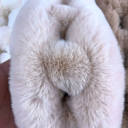 Beige plush faux fur cross scarf with a fluffy pom-pom detail.