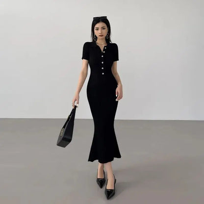 Black ribbed knit mermaid dress with buttons and fitted silhouette for resort wear.