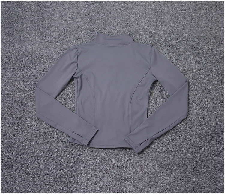 Grey polyester fitted sport jacket with a mock neck and thumbhole sleeves for gym training and yoga.