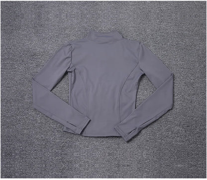 Grey polyester fitted sport jacket with a mock neck and thumbhole sleeves for gym training and yoga.