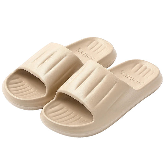 Pair of beige slide sandals with ridged straps and textured footbeds