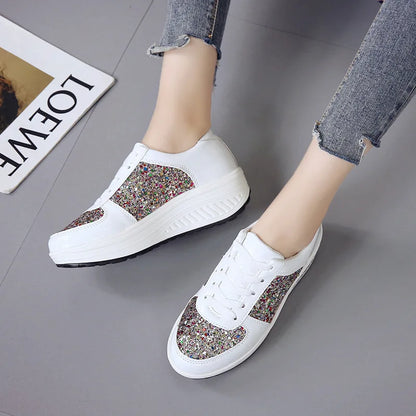 White lace-up platform sneakers with multi-colored sequin panels and chunky wedge soles.