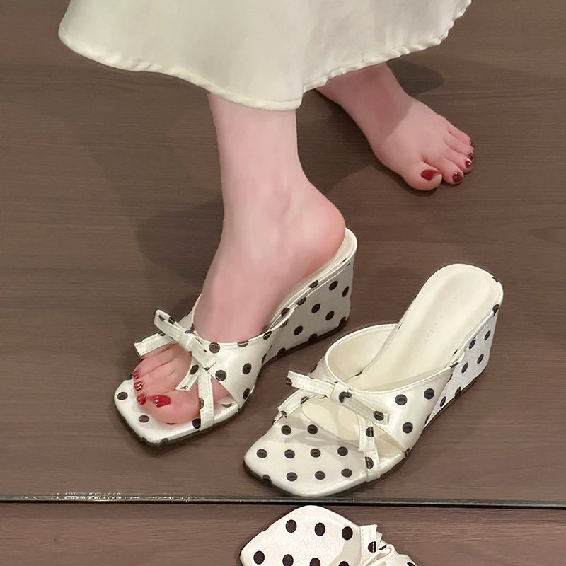White polka dot wedge sandals with bow detail and cushioned insole for casual wear.