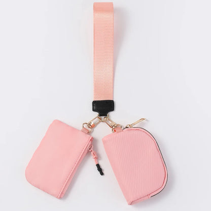 Pink nylon dual pouch wristlet wallet with zip closure for carrying cards, coins, and keys on the go.