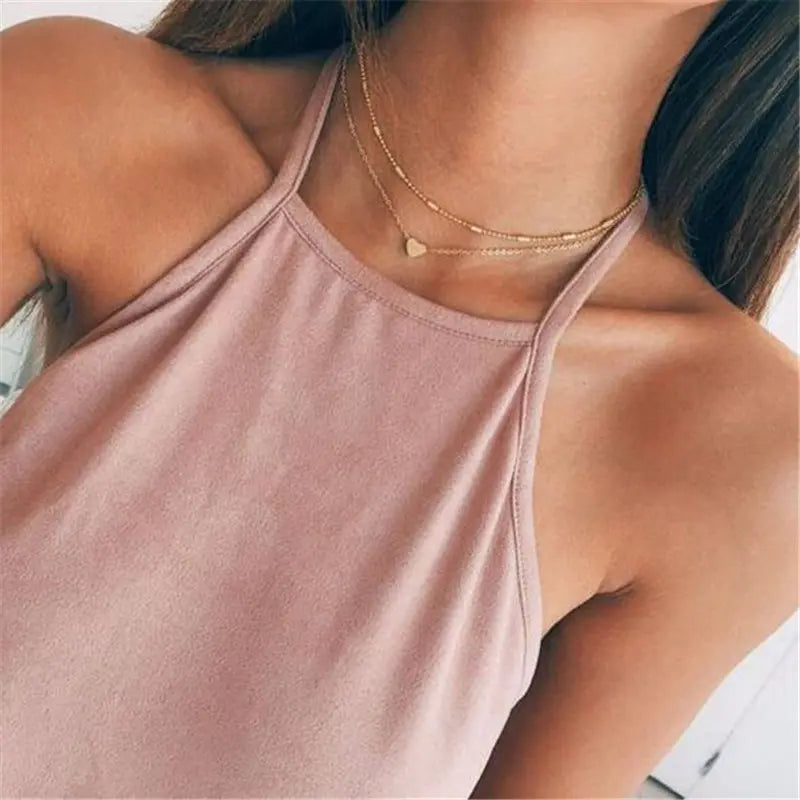 Gold-colored multilayer choker necklace featuring two delicate chains and a small heart pendant.
