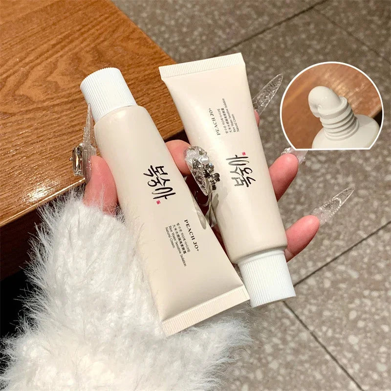 Two beige cosmetic squeeze tubes with white caps and black text, shown with white cream dispensed.