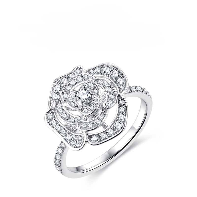 Silver camellia flower ring with pave-set moissanite stones and a single center diamond.