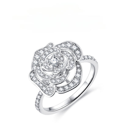 Silver camellia flower ring with pave-set moissanite stones and a single center diamond.