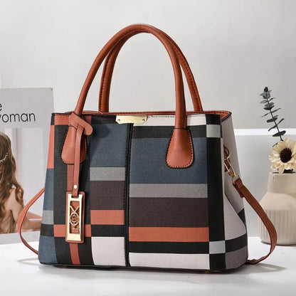 Multi-colored plaid structured tote bag with tan handles, zip closure, and gold hardware for everyday use.