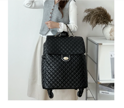 Black quilted leather travel trolley bag with chain handles, a gold-tone turn-lock closure, and wheels.