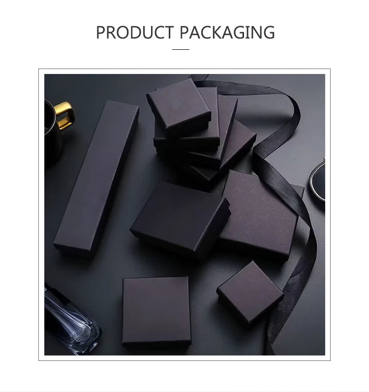 Set of black cardboard jewelry gift boxes of various shapes, including square and rectangular, with a black ribbon.