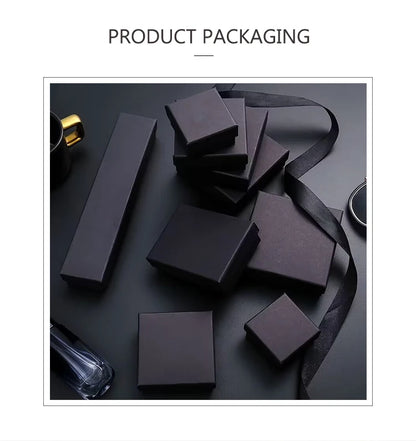 Set of black cardboard jewelry gift boxes of various shapes, including square and rectangular, with a black ribbon.