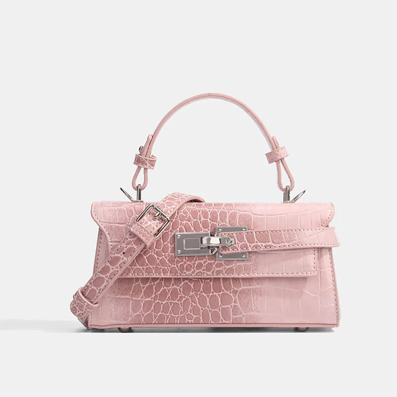 Pink faux leather crossbody bag with croc texture, silver zip closure, and adjustable strap for everyday errands.