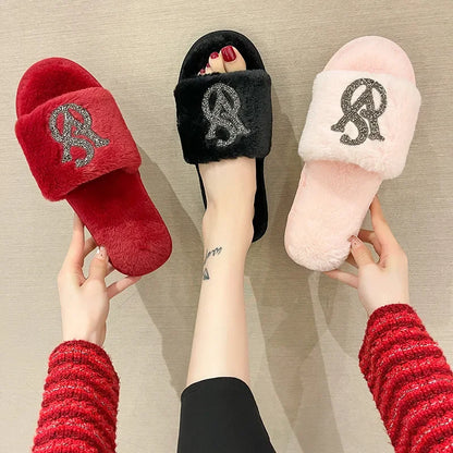 Red, black, and pink fur slippers with non-slip soles and rhinestone logos for indoor lounging.