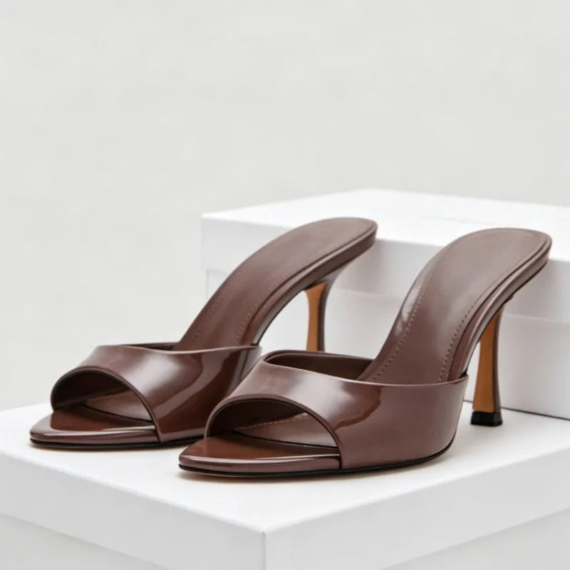 Brown patent leather open toe slip-on sandals with thin heels for evening parties.