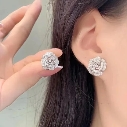 Silver-tone camellia flower stud earrings paved with sparkling clear cubic zirconia crystals.
